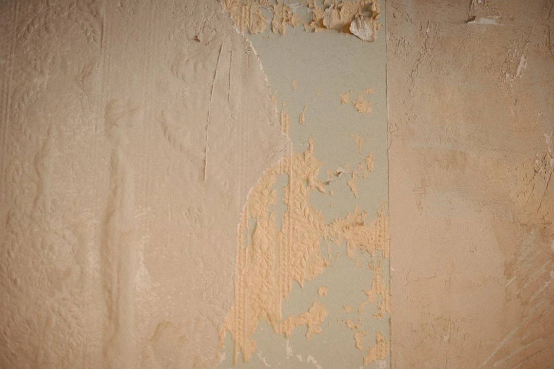 lähiplaanil sein, kust on eemaldatud vana tapeet ja pahtel, näha mitut erinevat viimistluskihti