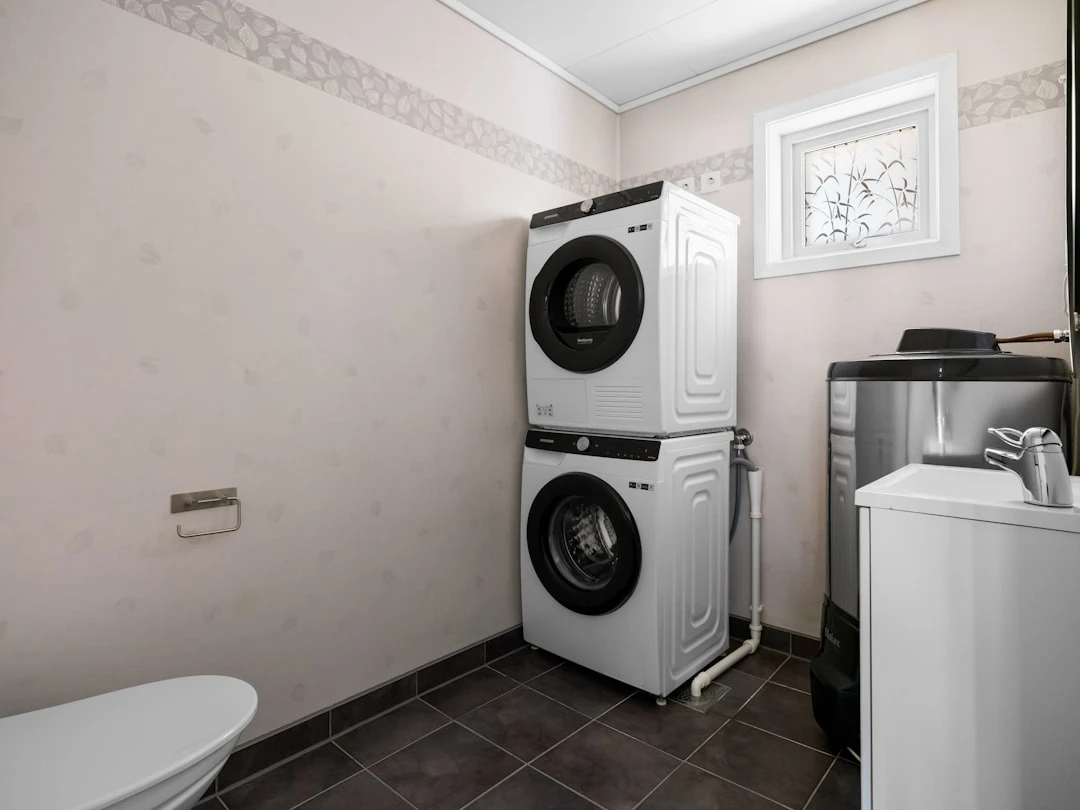 Pesumasin ja kuivati kaasaegses vannitoas, näidates ruumisäästlikku lahendust